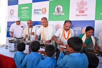 Dignitaries serve mid-day meals to schoolchildren during the Bhoomi Pooja of Bihar’s first kitchen
