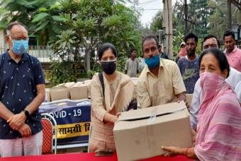 A beneficiary collects her COVID-19 relief grocery box