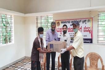 People patiently wait to collect the grocery kit