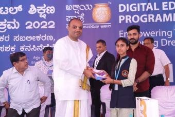 Shri Naveena Neerada Dasa - Director Strategic Communications (The Akshaya Patra Foundation) hands over a tablet to decrease the digital divide.