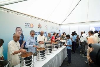 The excited dignitaries are happy serving various dishes to government school children.