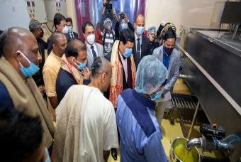 Dignitaries keenly observing the functioning of kitchen equipment