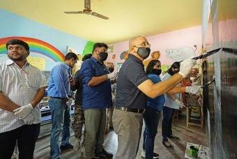 Mr Shridhar Venkat, CEO of The Akshaya Patra Foundation participates in painting one of the blackboards.